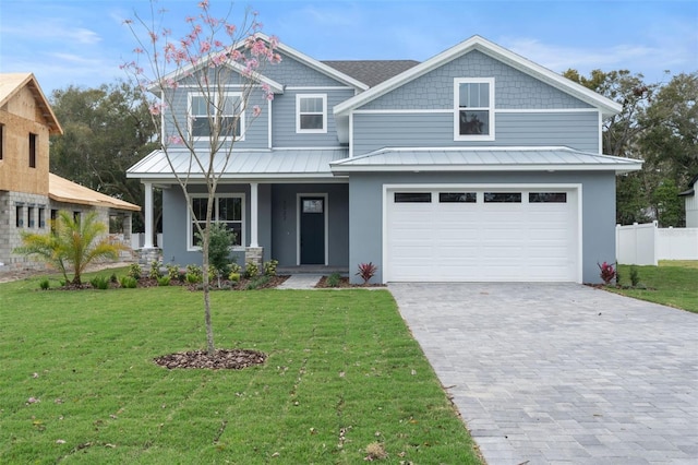 view of front of property featuring decorative driveway, covered porch, an attached garage, a front yard, and fence