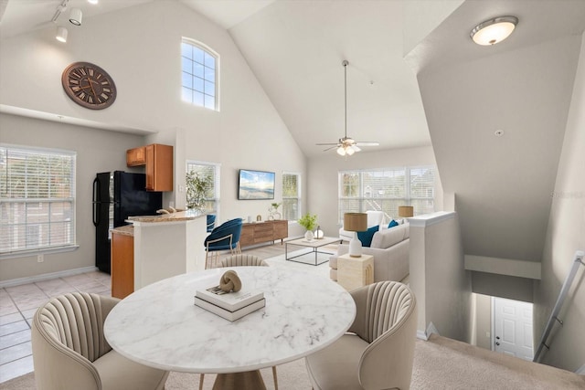 dining space featuring light tile patterned flooring, ceiling fan, and high vaulted ceiling