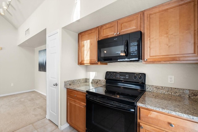 kitchen featuring light stone countertops, black appliances, vaulted ceiling, and light carpet