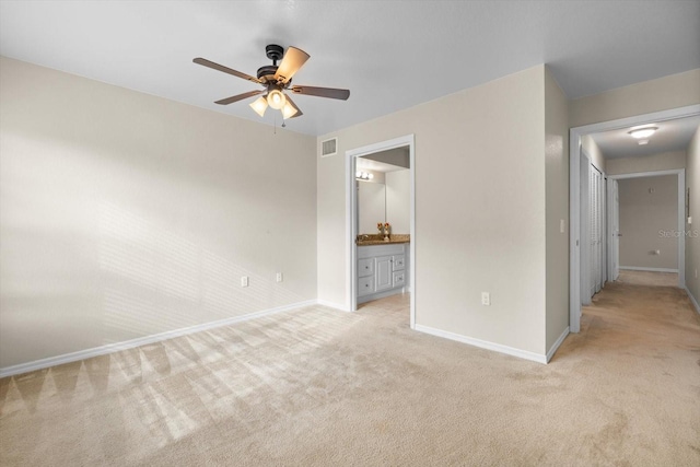 unfurnished bedroom featuring connected bathroom, ceiling fan, and light carpet