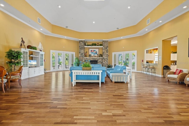 living area with french doors, a towering ceiling, and a healthy amount of sunlight