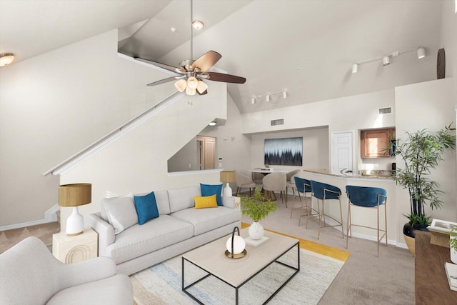 carpeted living room featuring ceiling fan, high vaulted ceiling, and rail lighting