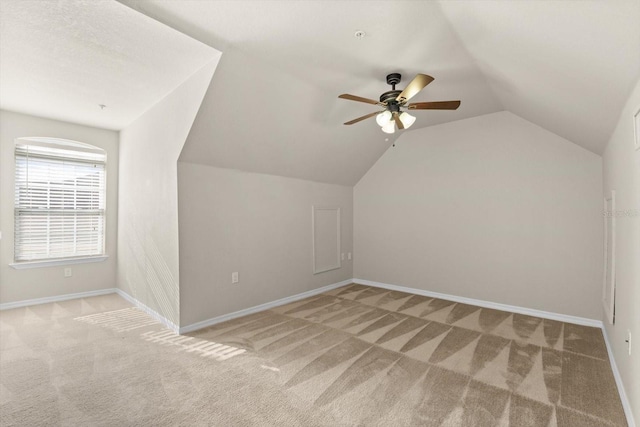 bonus room featuring ceiling fan, light carpet, and vaulted ceiling