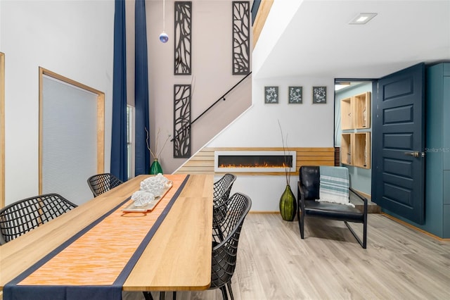 dining space featuring a fireplace and light hardwood / wood-style flooring