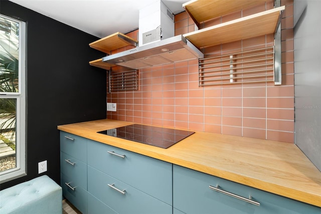 kitchen with wooden counters, decorative backsplash, black electric cooktop, and exhaust hood