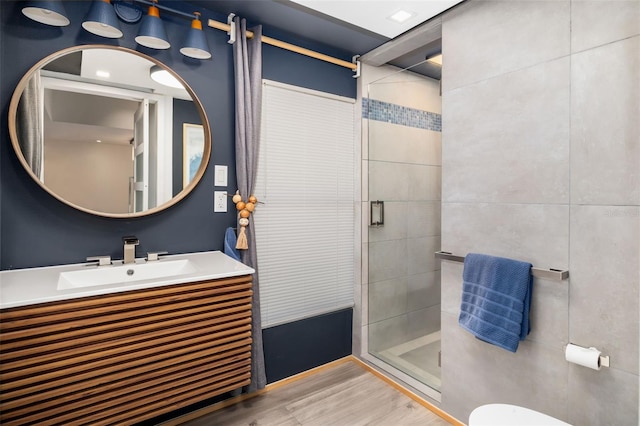 bathroom with toilet, hardwood / wood-style floors, vanity, and walk in shower