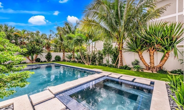 view of swimming pool featuring an in ground hot tub and a lawn