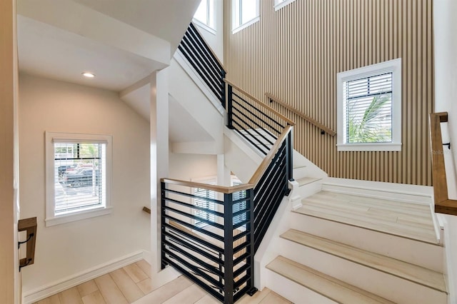 stairs with plenty of natural light and wood-type flooring