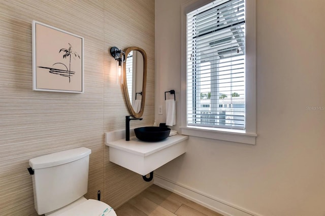 bathroom featuring toilet, sink, and tile walls