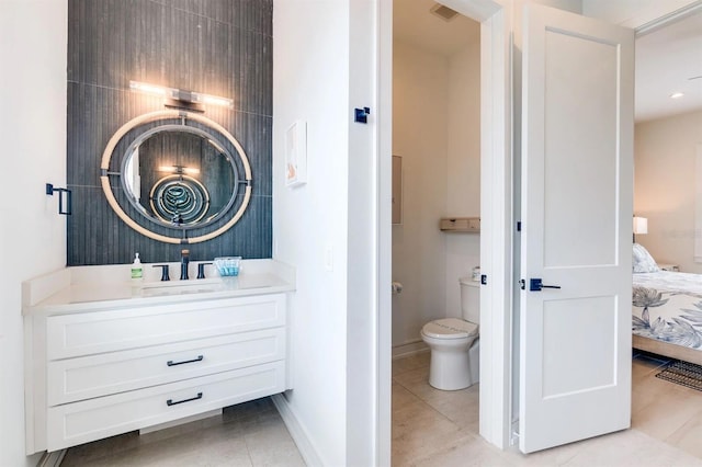 bathroom with tile patterned flooring, vanity, and toilet