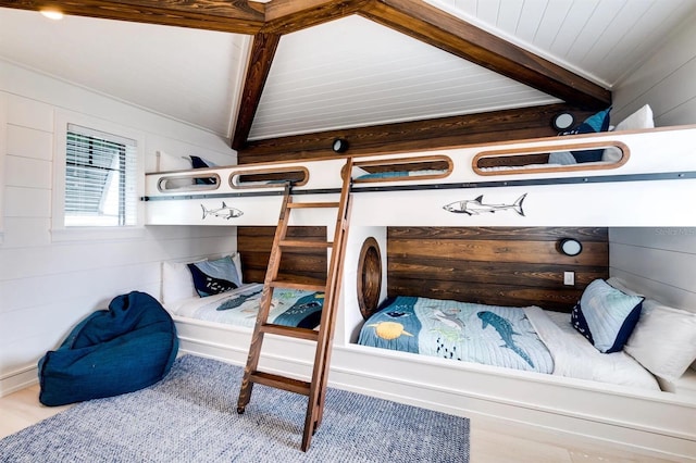 interior space with vaulted ceiling with beams and wood walls