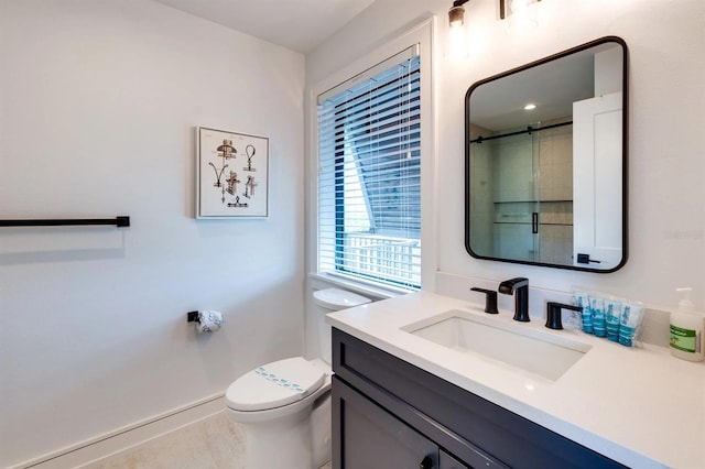 bathroom with an enclosed shower, vanity, and toilet