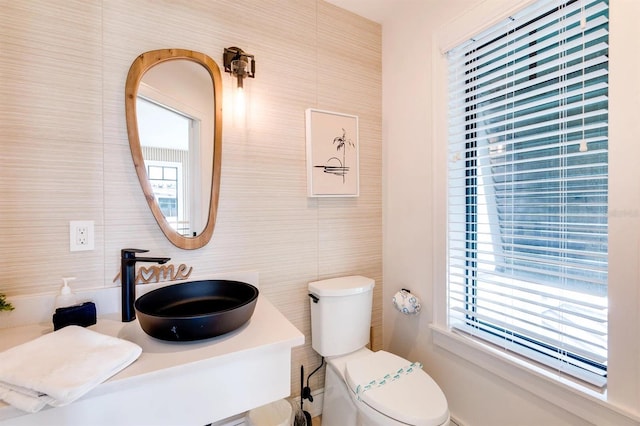 bathroom featuring tile walls, sink, and toilet