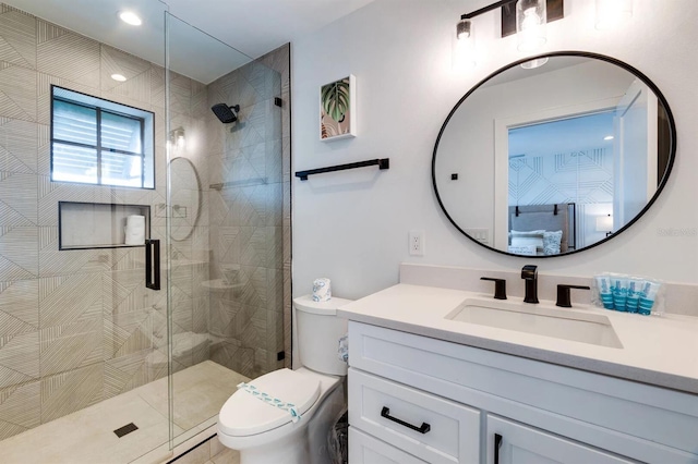 bathroom with vanity, a shower with shower door, and toilet