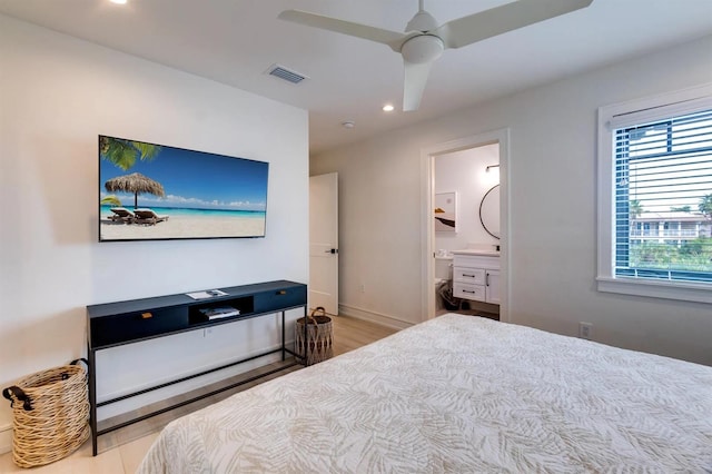 bedroom featuring ensuite bath, ceiling fan, and light wood-type flooring