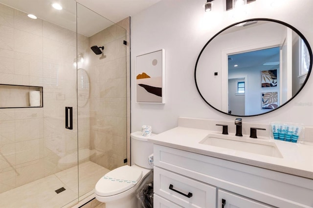 bathroom featuring a shower with door, vanity, and toilet