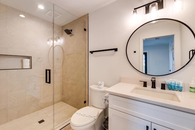 bathroom featuring vanity, toilet, and a shower with shower door