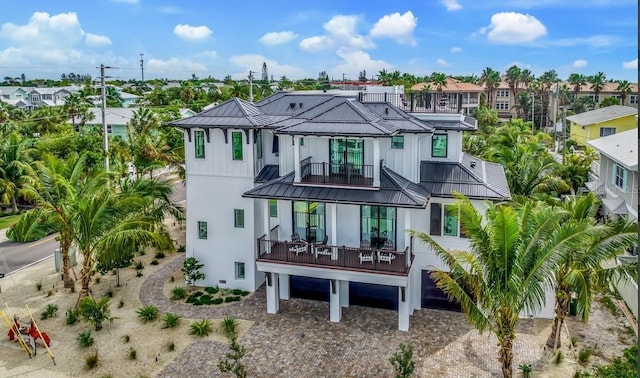 rear view of property featuring a garage and a balcony