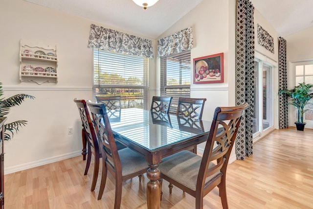 dining space featuring light hardwood / wood-style floors and lofted ceiling