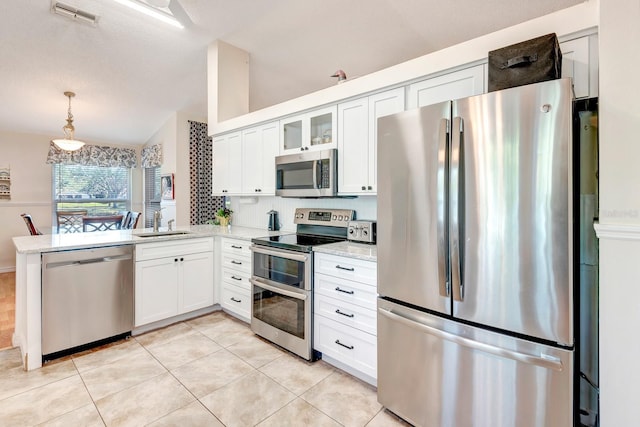 kitchen featuring white cabinets, decorative light fixtures, sink, and appliances with stainless steel finishes