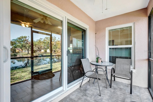 exterior space with ceiling fan and a water view