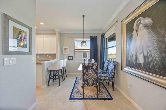 tiled dining area featuring sink and crown molding