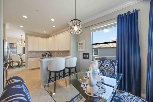 dining area featuring a chandelier, light tile patterned floors, and crown molding