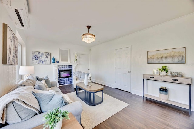 living room featuring a stone fireplace, dark hardwood / wood-style flooring, and a wall mounted AC