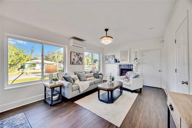 living room featuring a tile fireplace, a healthy amount of sunlight, dark hardwood / wood-style floors, and a wall mounted air conditioner