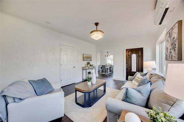 living room featuring a chandelier, dark hardwood / wood-style floors, and a wall mounted AC