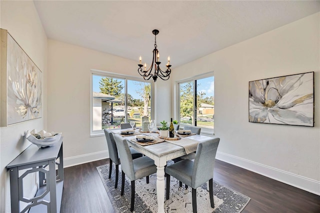 dining space with a healthy amount of sunlight, dark hardwood / wood-style flooring, and a chandelier