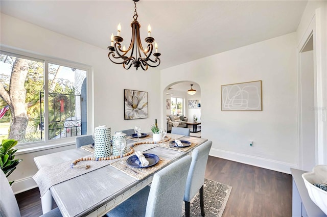 dining area featuring dark hardwood / wood-style flooring, a wealth of natural light, and a chandelier