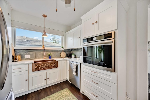 kitchen with white cabinetry, sink, pendant lighting, decorative backsplash, and appliances with stainless steel finishes