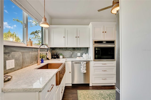 kitchen with light stone countertops, hanging light fixtures, stainless steel appliances, tasteful backsplash, and white cabinets