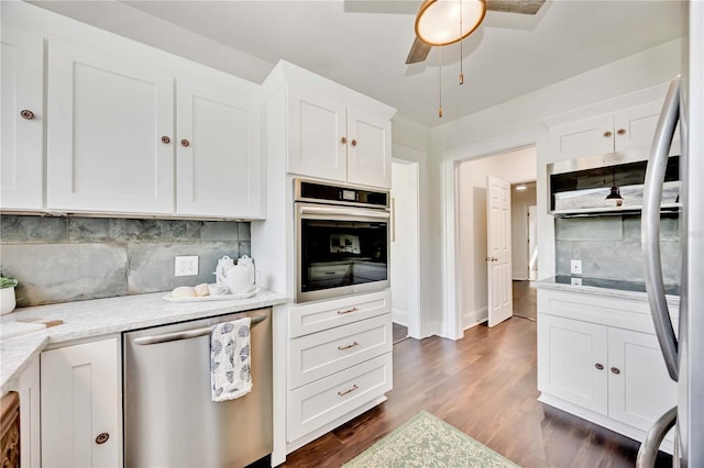 kitchen featuring white cabinetry, ceiling fan, light stone counters, dark hardwood / wood-style floors, and appliances with stainless steel finishes