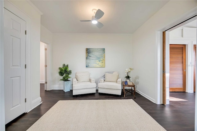 living area with ceiling fan and dark hardwood / wood-style flooring