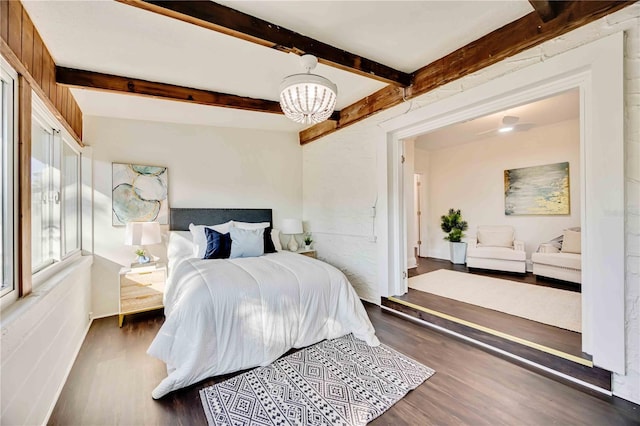 bedroom featuring a chandelier, beam ceiling, and dark hardwood / wood-style flooring