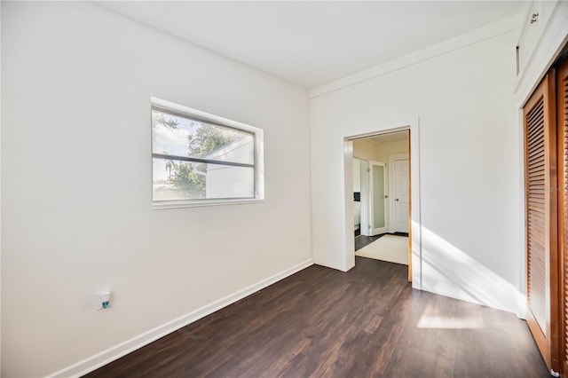 unfurnished bedroom with a closet and dark hardwood / wood-style floors