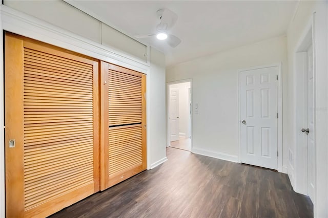 unfurnished bedroom featuring ceiling fan, dark hardwood / wood-style floors, and a closet