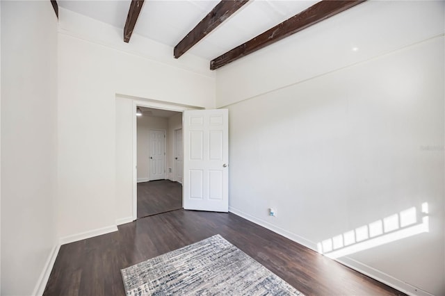 unfurnished room featuring beamed ceiling and dark wood-type flooring