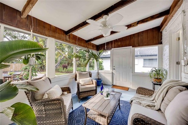 sunroom with a healthy amount of sunlight, ceiling fan, and lofted ceiling with beams