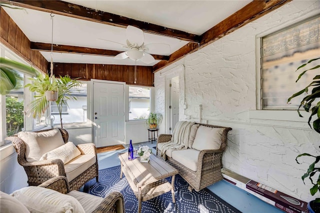 sunroom with beamed ceiling and ceiling fan