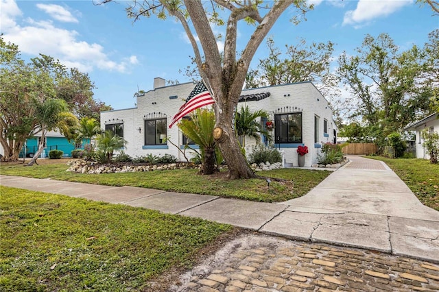 mediterranean / spanish home featuring a front lawn