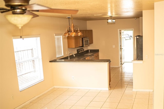 731 Cristelle Jean Dr, Ruskin, FL 33570 - kitchen featuring appliances with stainless steel finishes, a peninsula, light tile patterned floors, dark countertops, and ceiling fan