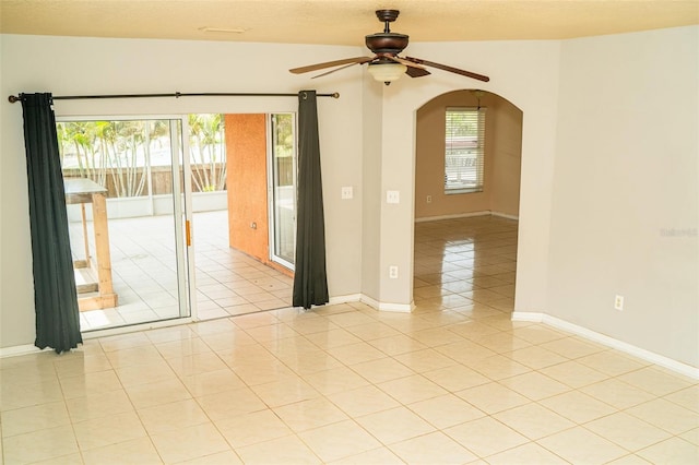 731 Cristelle Jean Dr, Ruskin, FL 33570 - empty room with light tile patterned floors, arched walkways, baseboards, and ceiling fan