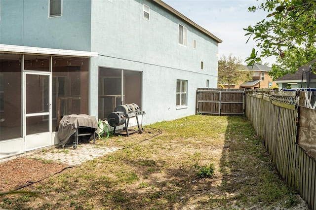 731 Cristelle Jean Dr, Ruskin, FL 33570 - rear view of house featuring a fenced backyard, a sunroom, and stucco siding