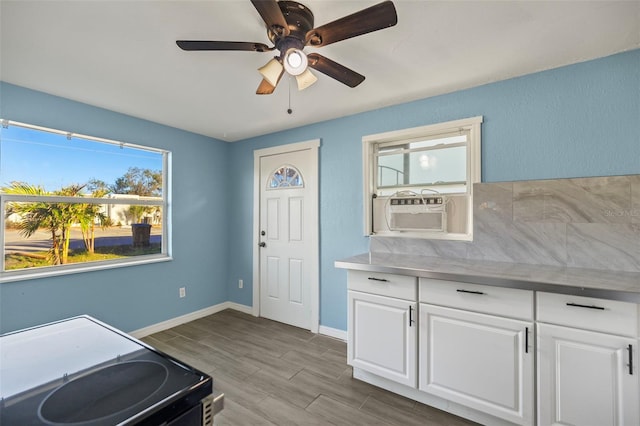 kitchen with ceiling fan, black electric range oven, light hardwood / wood-style flooring, cooling unit, and white cabinets