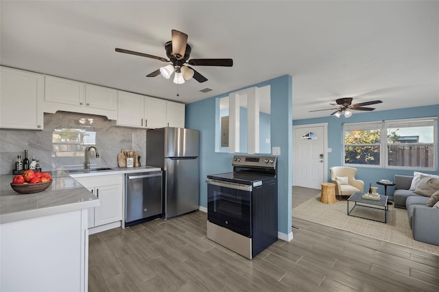 kitchen with ceiling fan, backsplash, sink, white cabinetry, and appliances with stainless steel finishes