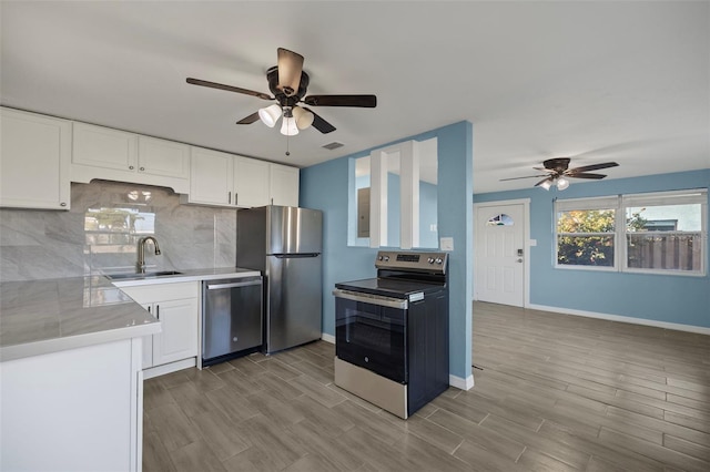 kitchen featuring white cabinetry, appliances with stainless steel finishes, backsplash, and sink