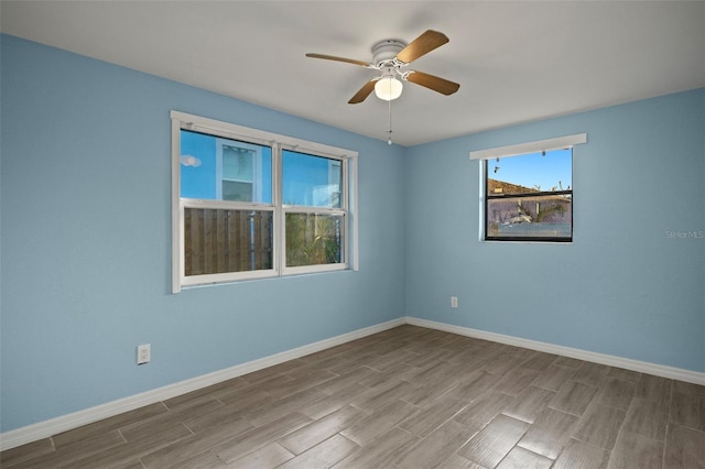 spare room with ceiling fan and light wood-type flooring